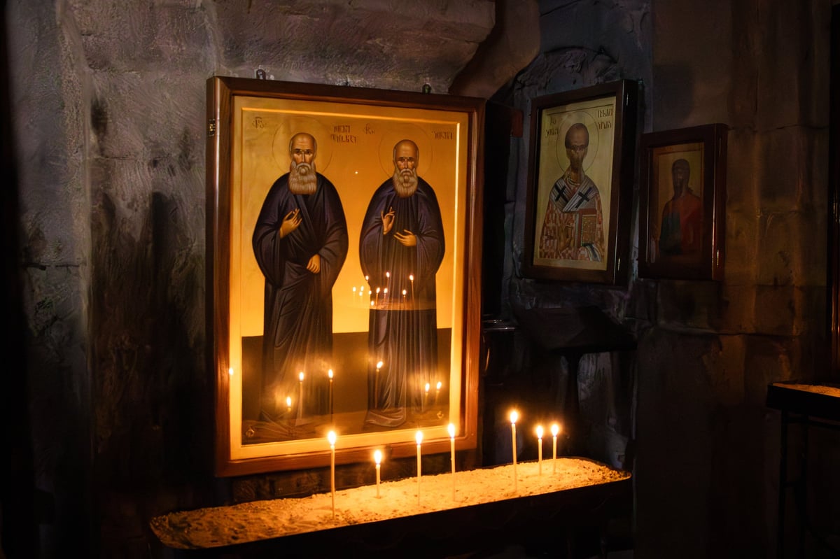 Gergeti Trinity Monastery Church in Georgia, icon paintings illuminated by candlelight