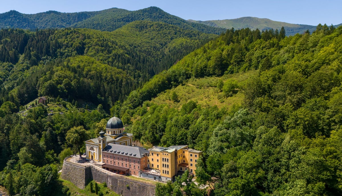 Beautiful aerial photograph of monastery surrounded by lush green hills