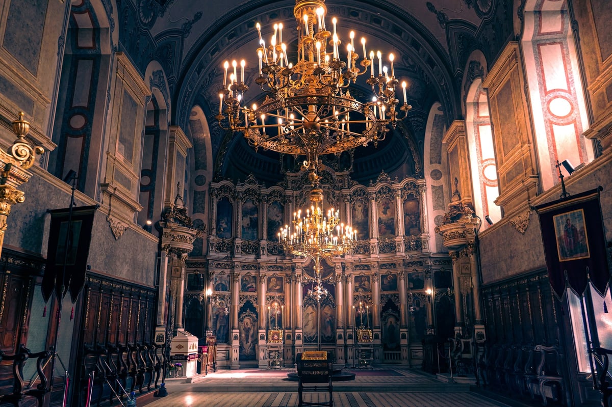 Orthodox church interior with golden chandelier and iconostasis