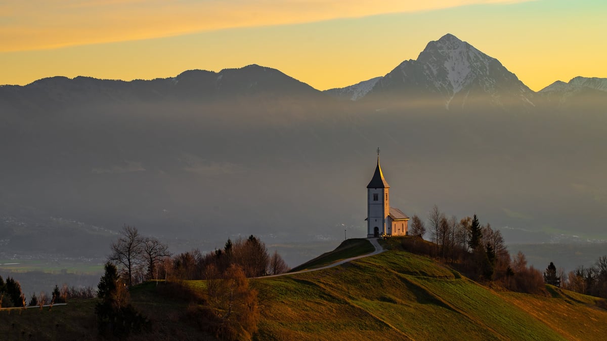 Beautiful landscape with church on hill, sunrise golden light